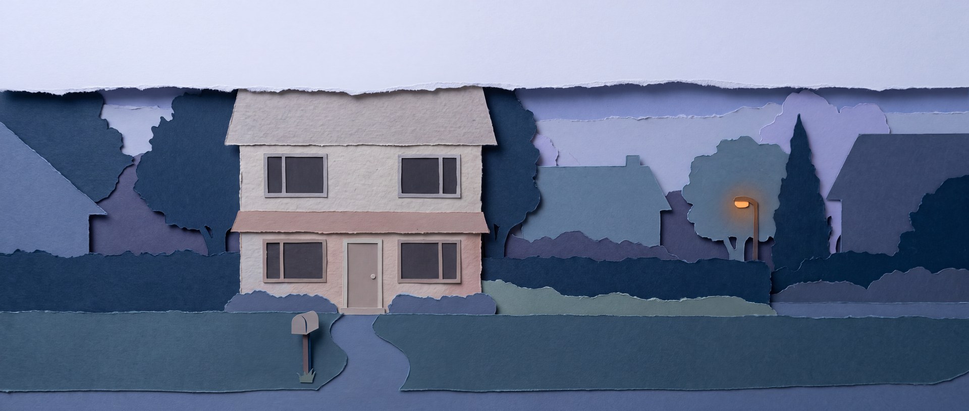 A dark two-storey rental house at dusk with a mailbox and a path to the door.